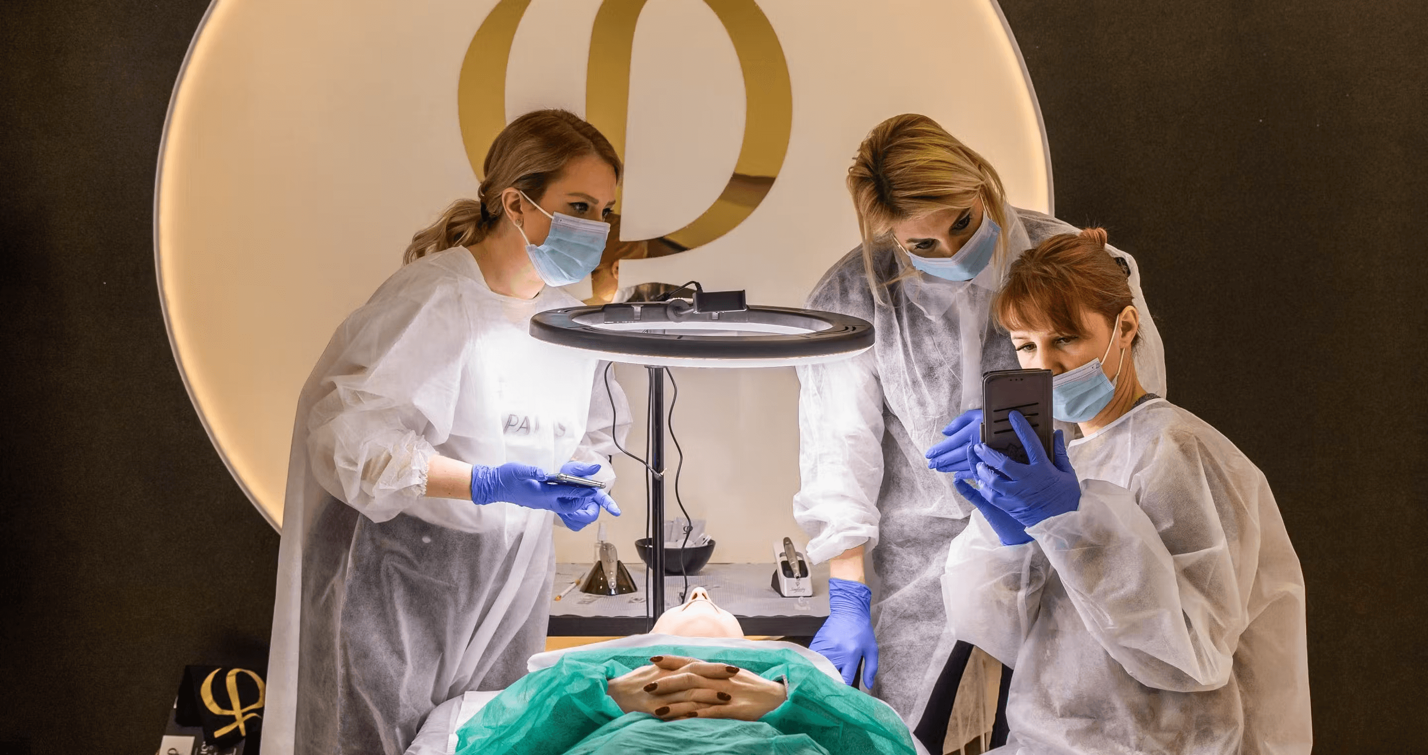 Students practicing microblading techniques under instructor supervision.